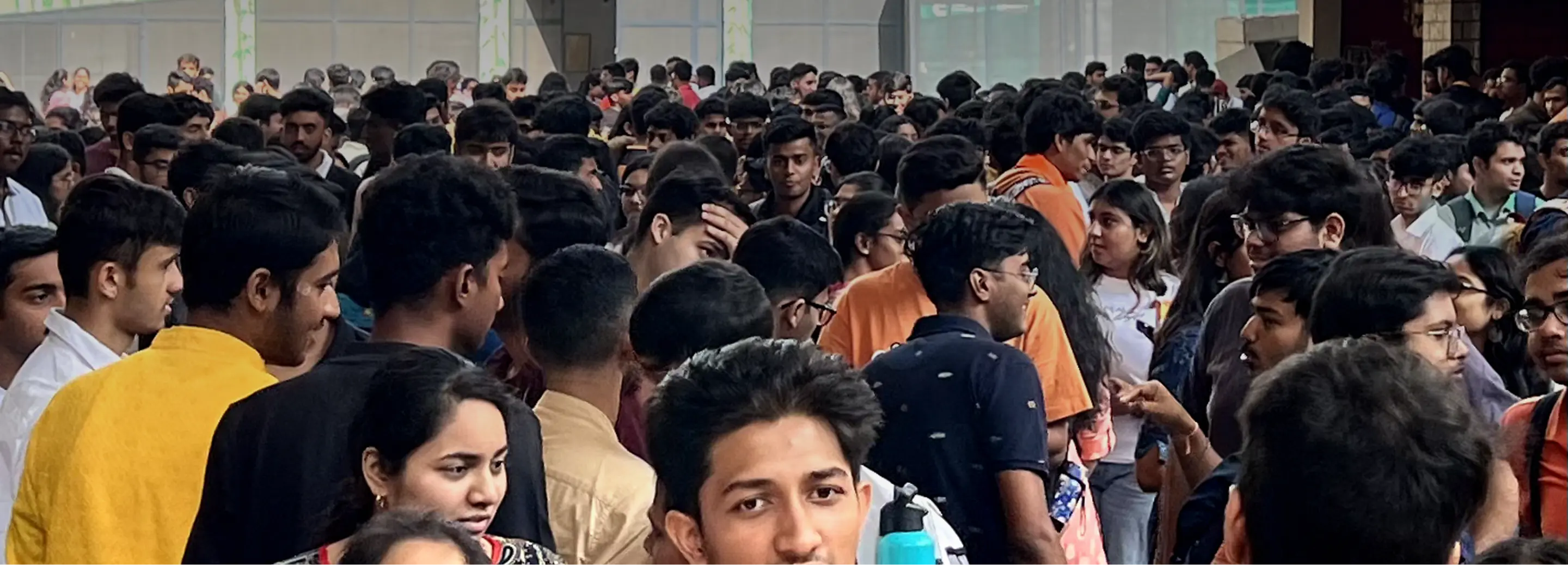 A dense crowd of university students packed together in campus during break time, illustrating the chaotic environment that Dello was designed to solve.
